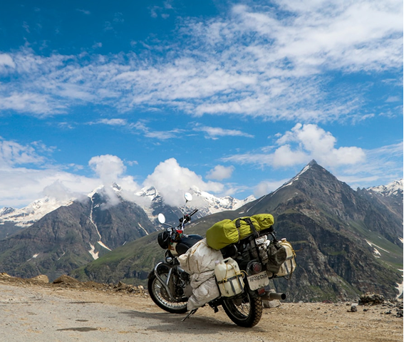 Motorbike parked with mountain peaks in the background